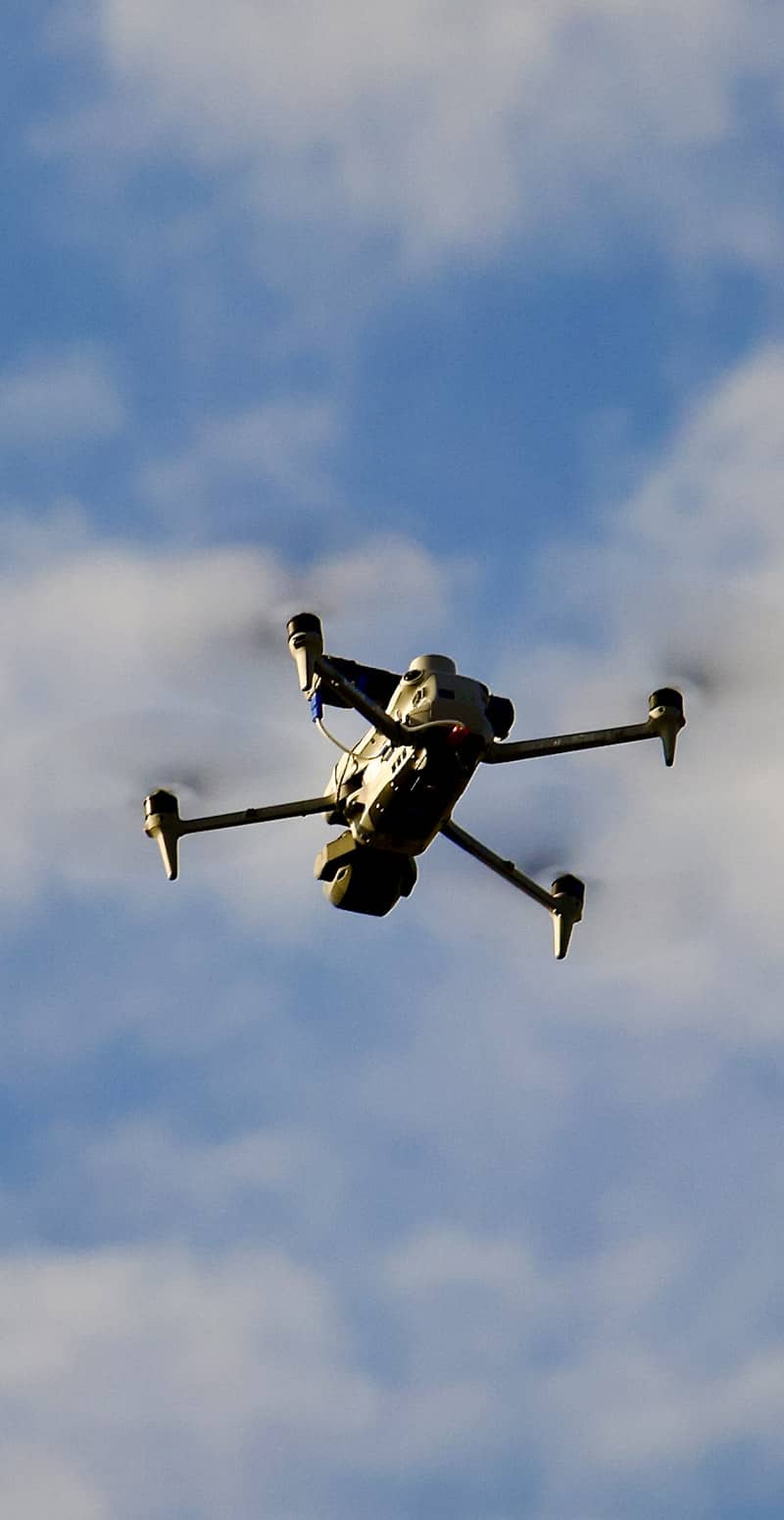 Drone dans le ciel inspectant une toiture industrielle en Seine-Maritime